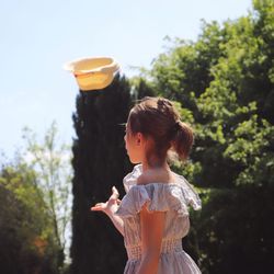 Cute girl standing against trees