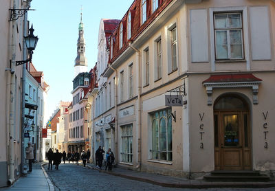 People walking on street amidst buildings in city