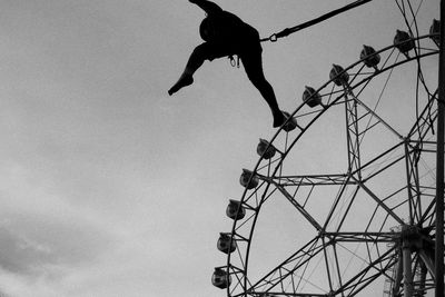 Low angle view of silhouette crane against clear sky