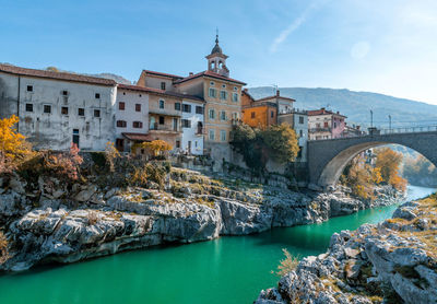 Idyllic old town on rocky bank of green river. kanal ob soci in slovenia.