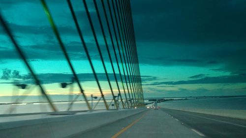 Suspension bridge against cloudy sky