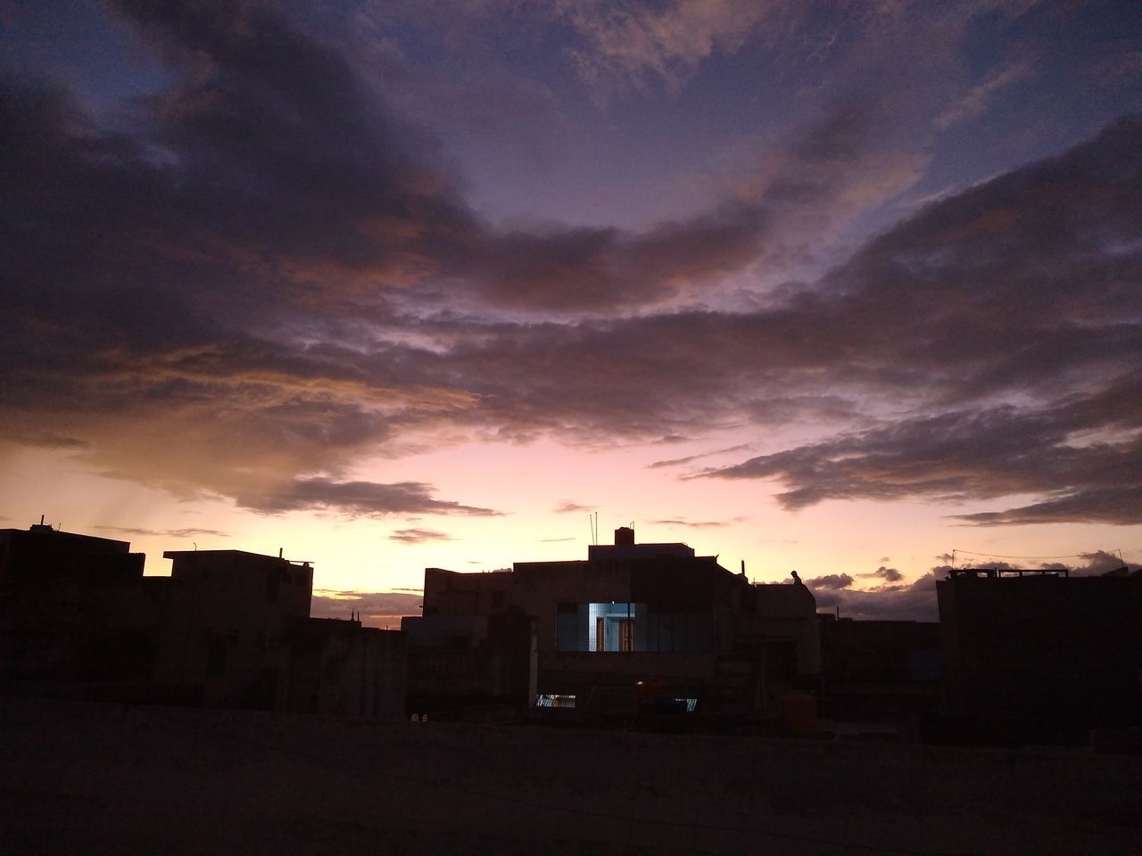 SILHOUETTE BUILDINGS AGAINST DRAMATIC SKY