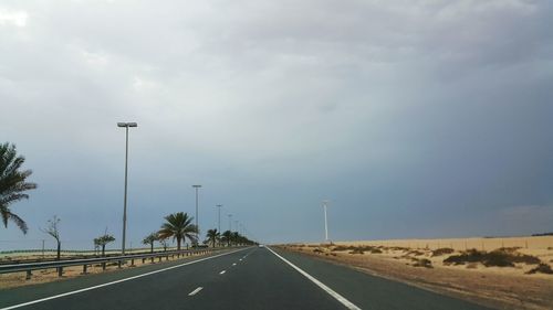 Empty road against cloudy sky