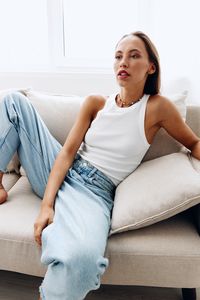 Portrait of woman sitting on sofa at home