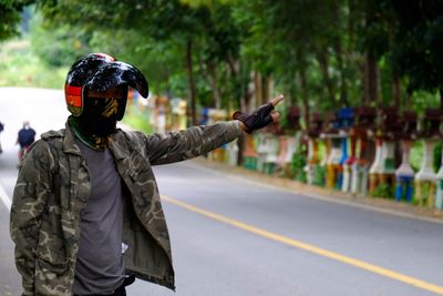 Man in helmet hitchhiking on road