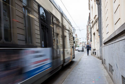 Blurred motion of people in city against sky