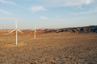 Windmills in california desert near ocotillo, with highway in distance