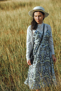 Thoughtful mid adult woman standing on grassy field