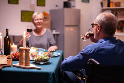 Portrait of smiling friends toasting drinks on table