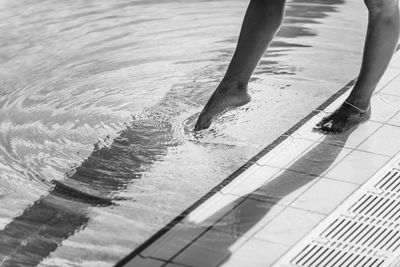 Low section of man standing in water