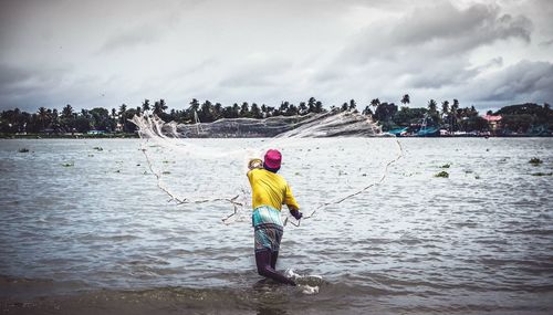 Man standing in sea against sky