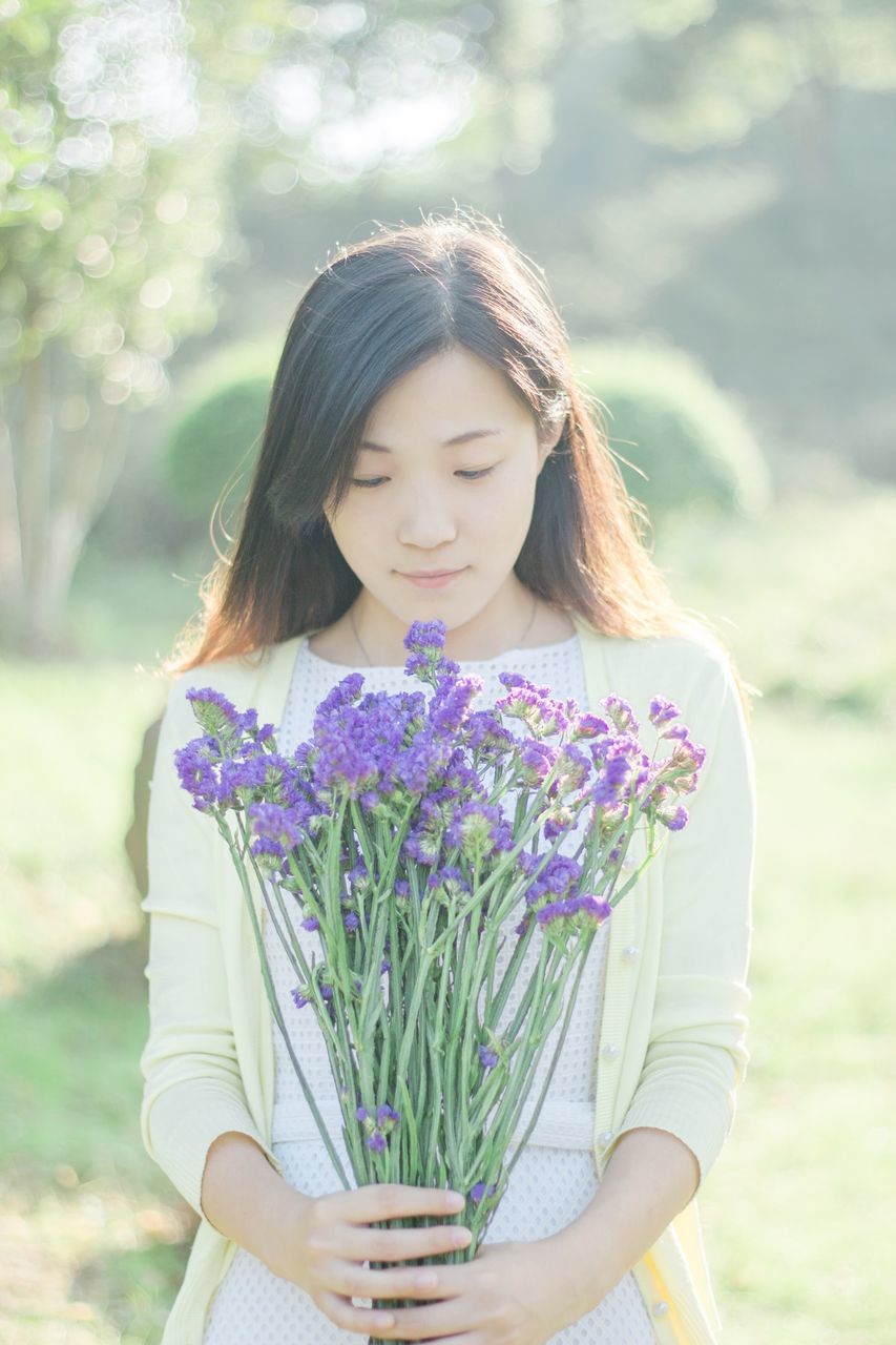 focus on foreground, lifestyles, leisure activity, flower, person, waist up, casual clothing, holding, three quarter length, girls, childhood, standing, young women, fragility, blond hair, smiling, elementary age, front view