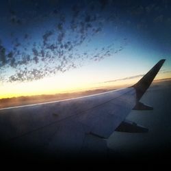 Cropped image of airplane flying over cloudscape