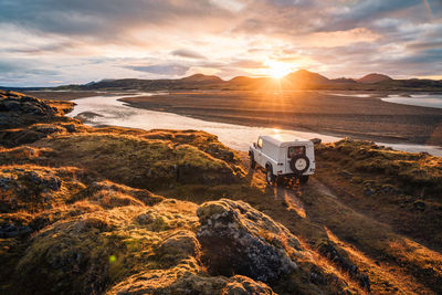4x4 truck looks out over sunrise landscape in iceland