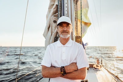 Portrait of senior man at sea against sky