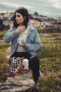 Beautiful young woman sitting outdoors