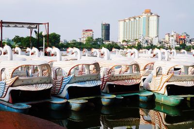 Group of people on boats in city against sky