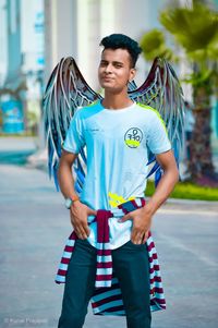 Portrait of young man standing on street in city