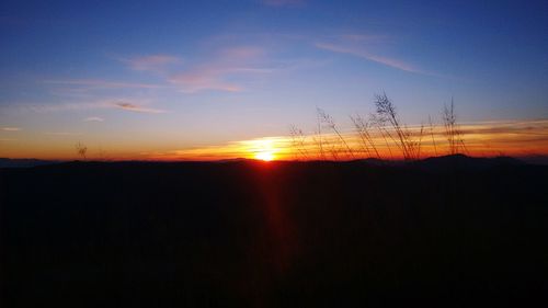 Silhouette landscape against sky during sunset