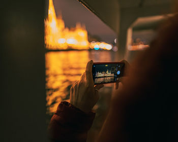 Cropped image of person holding illuminated light