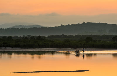 Scenic view of lake against sky during sunset