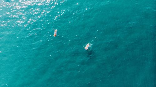 Aerial view of man and woman on inflatable raft in sea