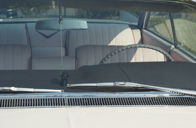 Steering wheel seen through windshield of vintage car