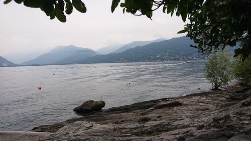 Scenic view of sea and mountains against sky