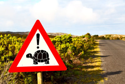 Close-up of road sign against sky