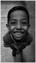 High angle portrait of smiling boy standing on floor