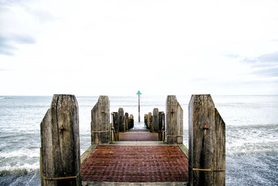 View of jetty in sea against sky
