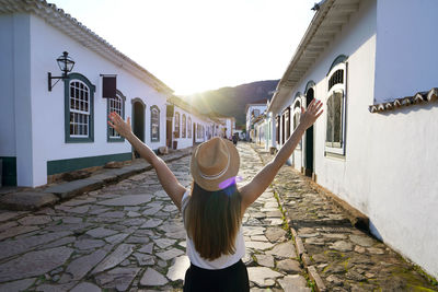 Rear view of young woman standing against building