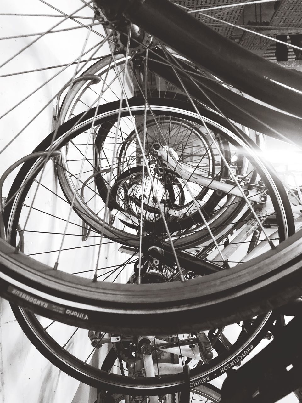 bicycle, transportation, wheel, low angle view, metal, day, mode of transportation, close-up, architecture, outdoors, travel, land vehicle, real people, tire, focus on foreground, spoke, group of people, city