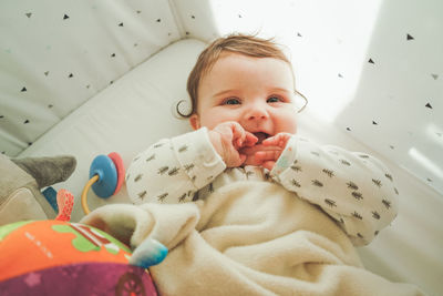 Directly above shot of cute baby girl lying on bed at home