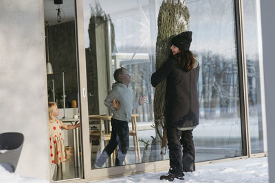 Woman carrying christmas in front of house