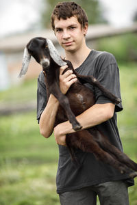 Local agriculture, farmer's day 12 october. a man with a goat in his arms, natural products.