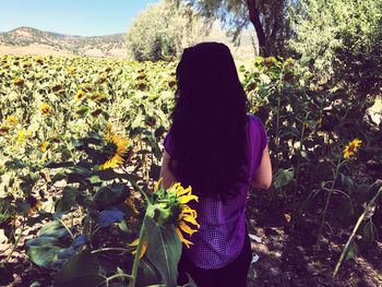 Rear view of woman standing in field