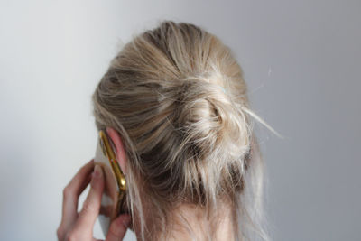 Close-up portrait of woman with hair against white background
