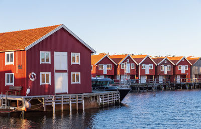 Houses by building against clear sky