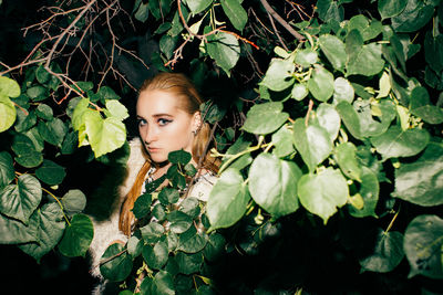 Portrait of woman standing amidst plants