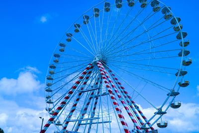 Low angle view of ferris wheel against blue sky