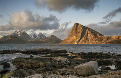 Scenic view of sea by rocks against sky