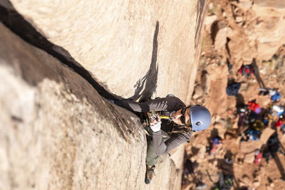 High angle view of male hiker climbing mountain