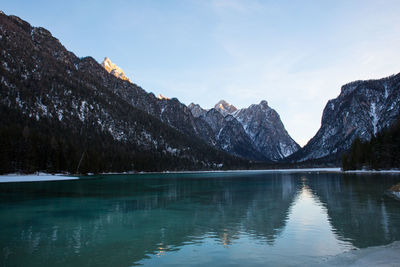 Scenic view of lake by mountains against sky