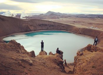 High angle view of men on mountains by lake