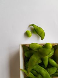 Close-up of green edamame against white background