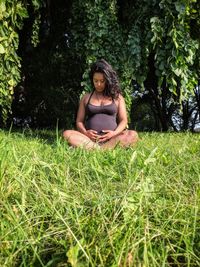 Full length of woman sitting on field