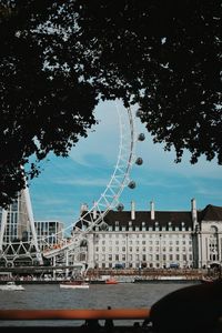 View of ferris wheel in city against sky