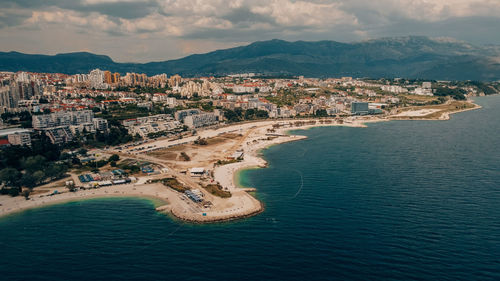 High angle view of city by sea against sky