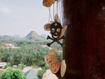 Close-up of bell hanging on rope against sky